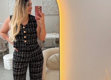 Mulher elegante no JL CLINIC, Linda-a-velha, Lisboa, PT, refletida em espelho, ambiente sofisticado.