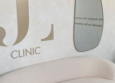 Interior do JL CLINIC PORTO em Matosinhos, Porto, PT com logo elegante e sofá moderno.