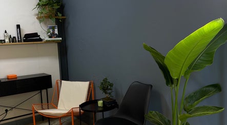 Stylish waiting area at Jack Moran Hair, Barcelona, Cataluña, ES featuring modern chairs and a vibrant plant.