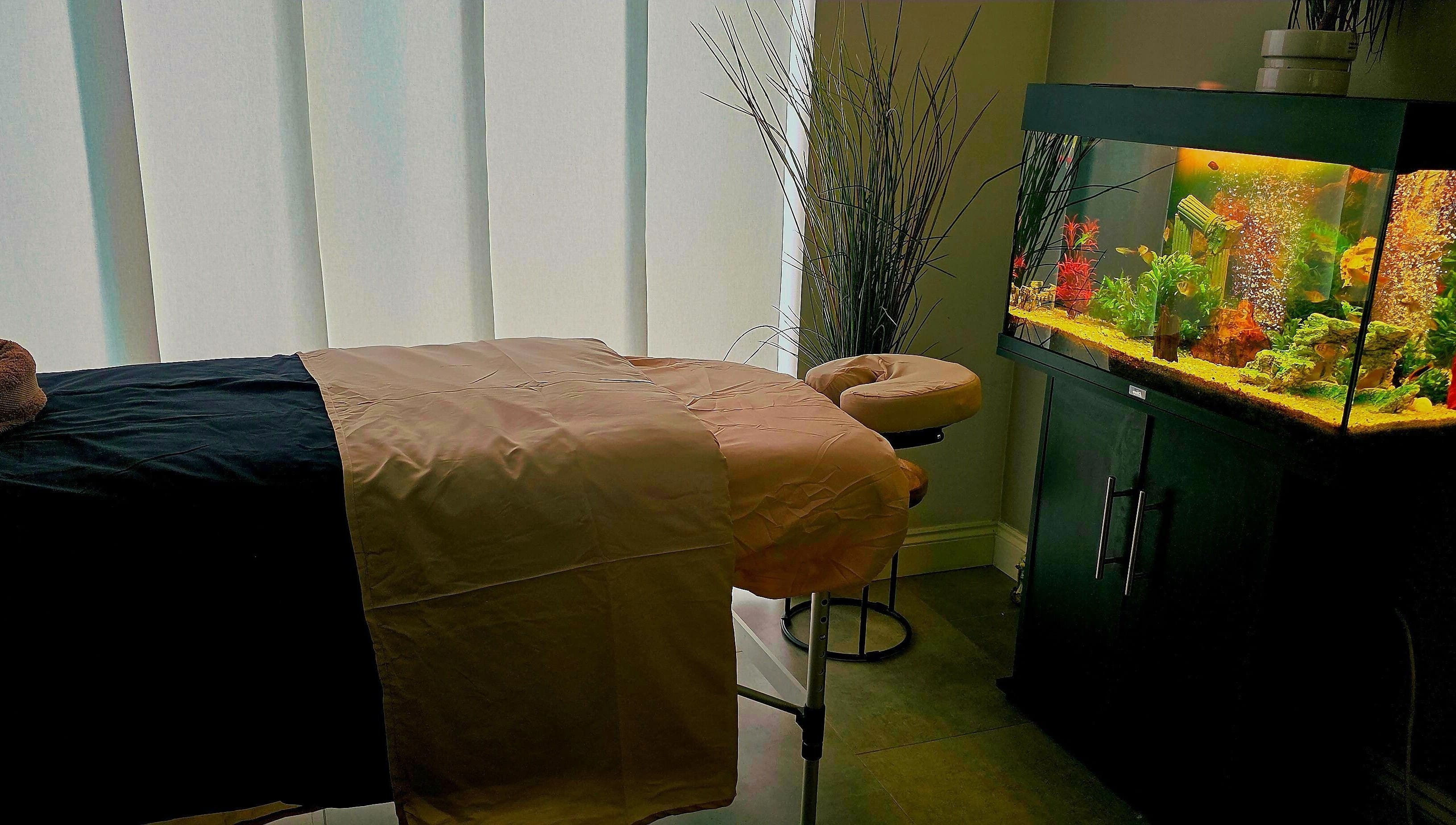 Tranquil massage room at Still Waters MK, Tattenhoe Park, England, GB with ambient lighting and aquarium.