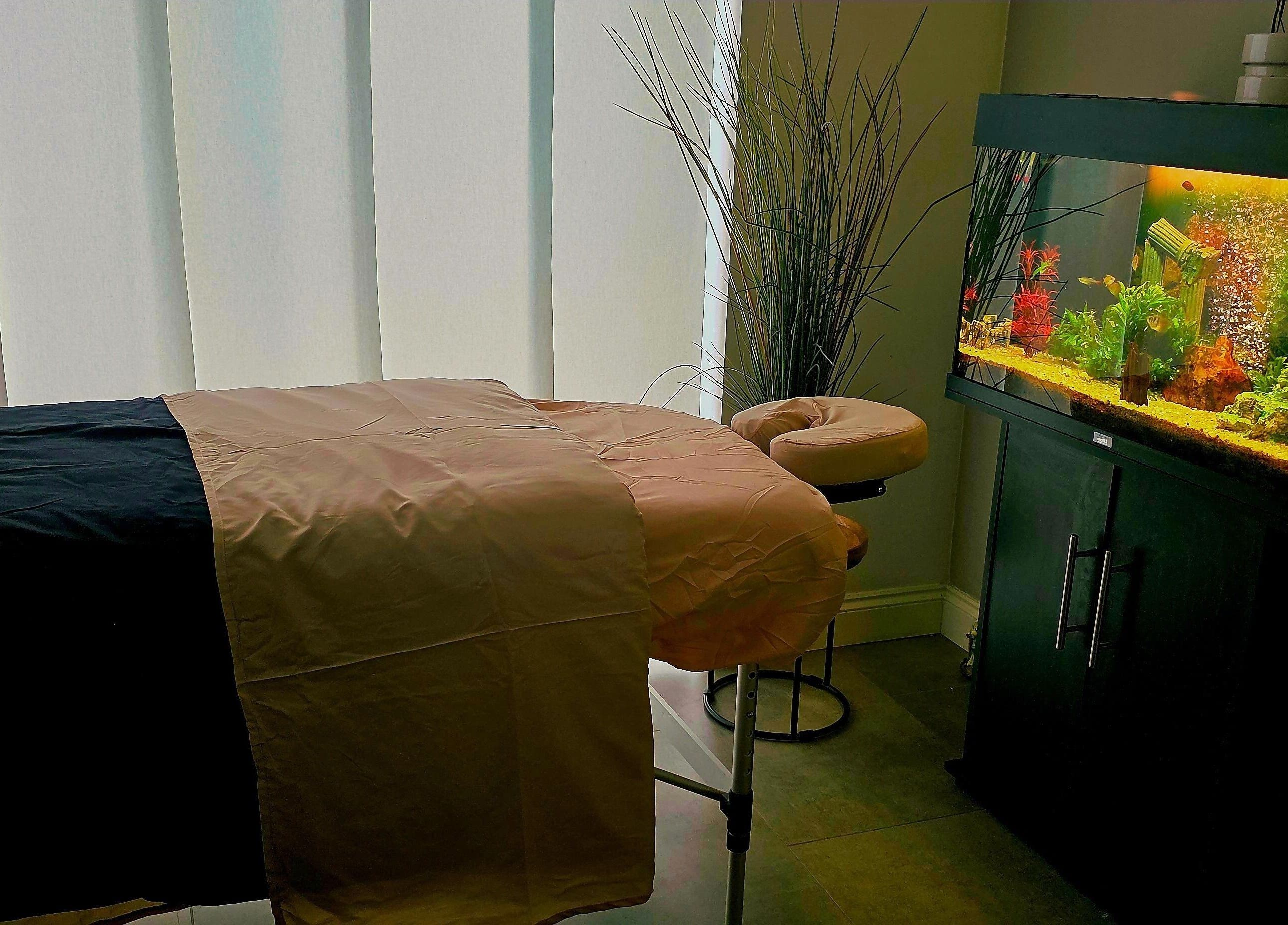 Tranquil massage room at Still Waters MK, Tattenhoe Park, England, GB with ambient lighting and aquarium.