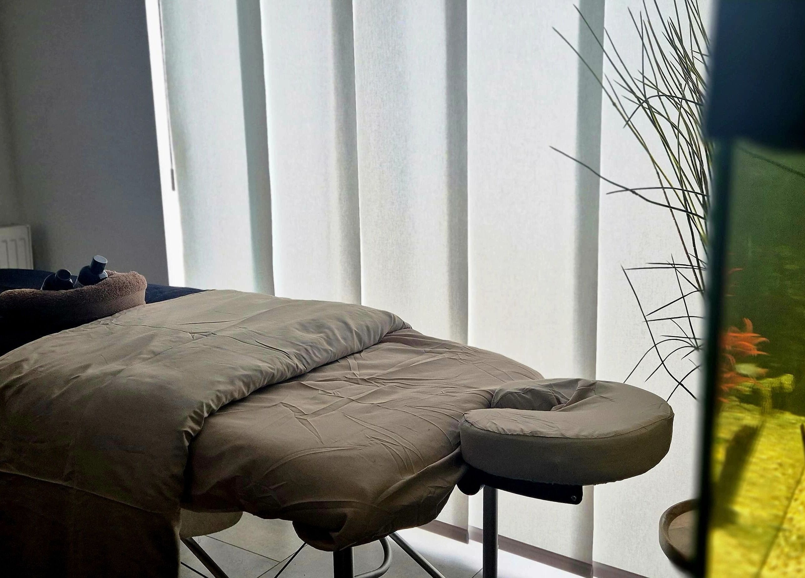 Tranquil massage room at Still Waters MK, Tattenhoe Park, England, GB with massage bed and aquarium.