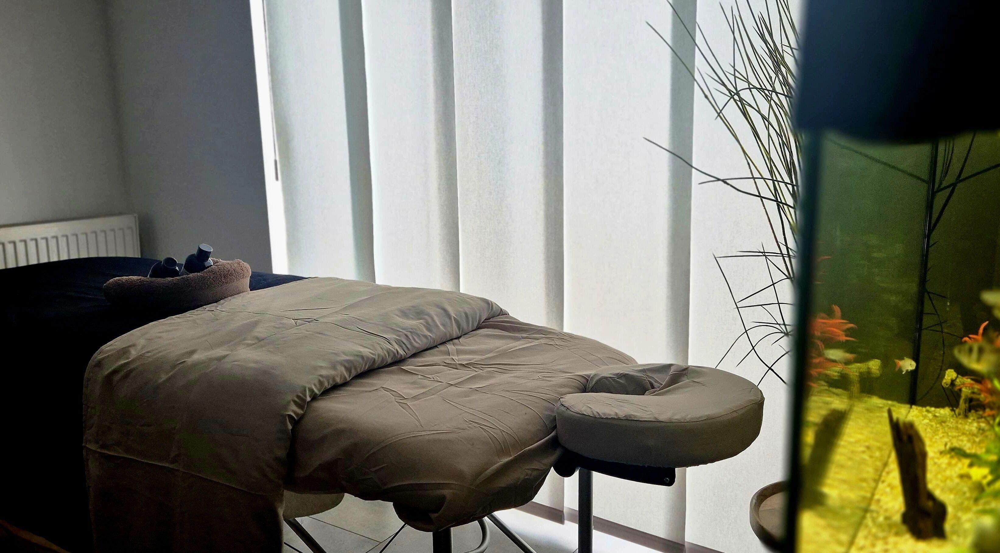 Tranquil massage room at Still Waters MK, Tattenhoe Park, England, GB with massage bed and aquarium.