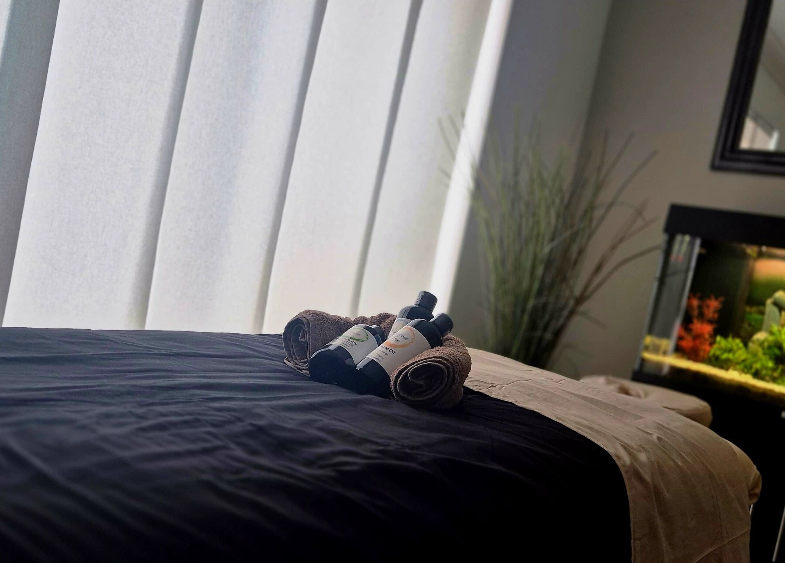 Massage table with oils at Still Waters MK, Tattenhoe Park, England, GB, offering calm and relaxation.