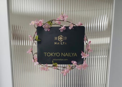 Tokyo Nailya sign adorned with pink flowers at London, England, GB entrance.