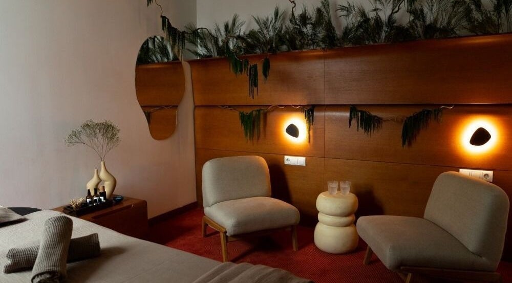 Serene spa room at Sitgajos masažas, Vilnius. Cozy seating and soft lighting create a peaceful vibe.