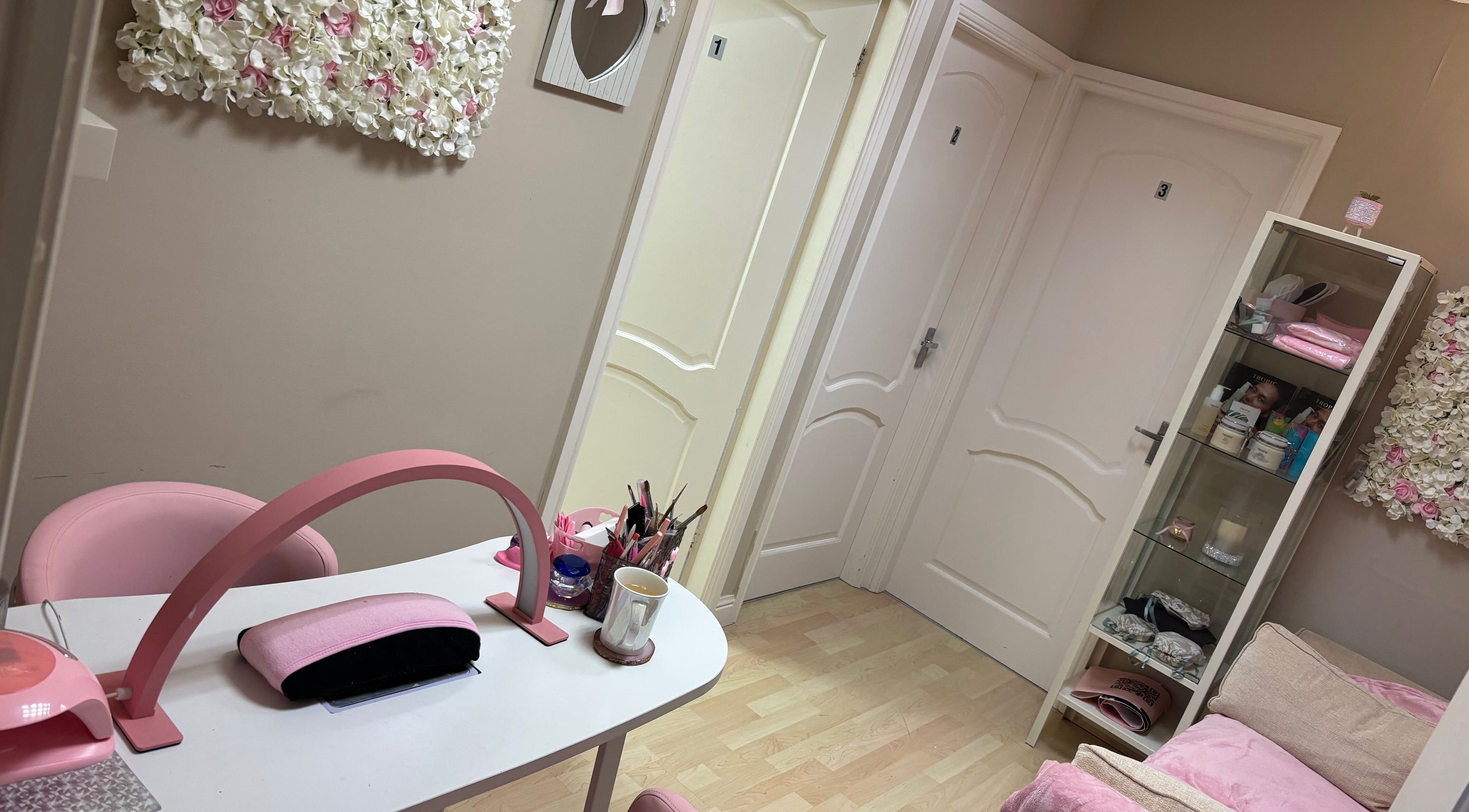 Cozy pink-themed treatment room at Lush Beauty, Stafford, England, GB showcasing nail station and floral decor.