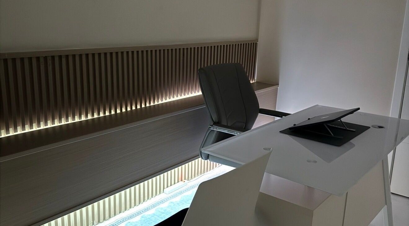 Modern office at Dr. Ruddock Dermatology, Kingston, St. Andrew Parish, JM with sleek chair and glass desk.