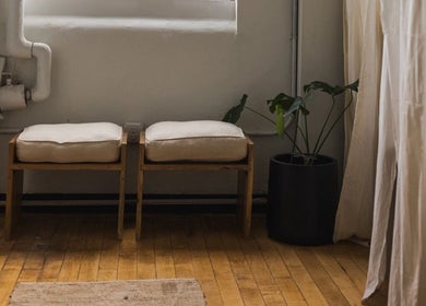 Relaxing seating area at LGHTTouch in Philadelphia, Pennsylvania, US with wooden benches and lush plant.