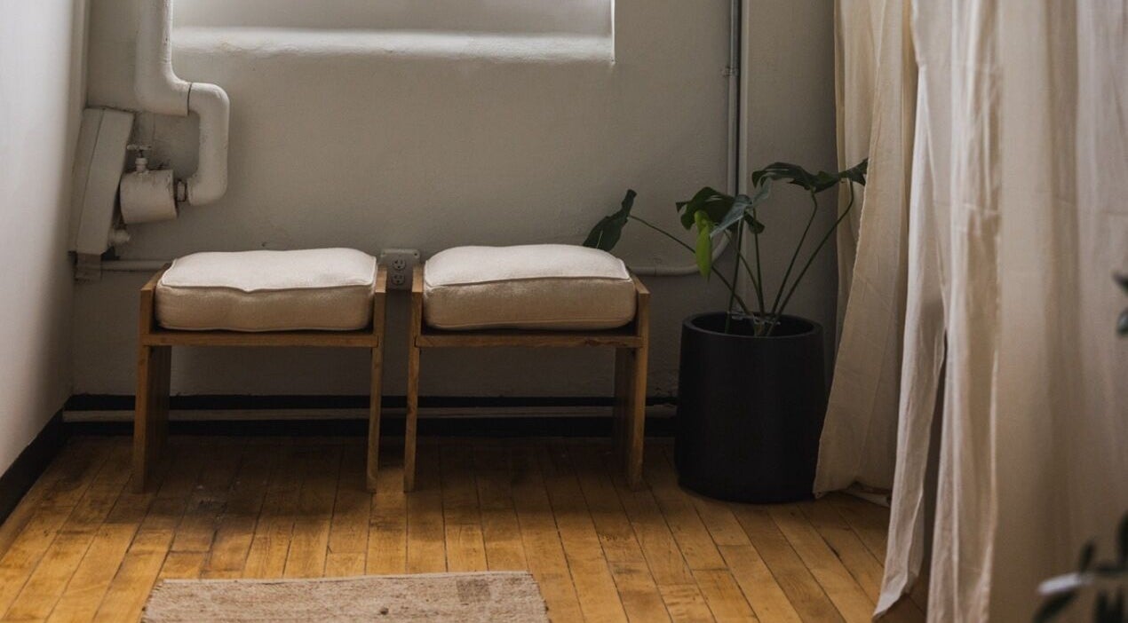 Relaxing seating area at LGHTTouch in Philadelphia, Pennsylvania, US with wooden benches and lush plant.