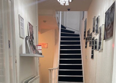 Stylish staircase at SMP Aesthetics Kent, Royal Tunbridge Wells, England, GB adorned with chic wall art.