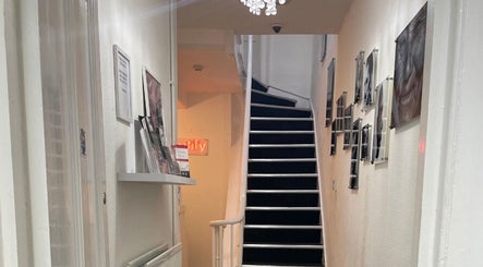 Stylish staircase at SMP Aesthetics Kent, Royal Tunbridge Wells, England, GB adorned with chic wall art.