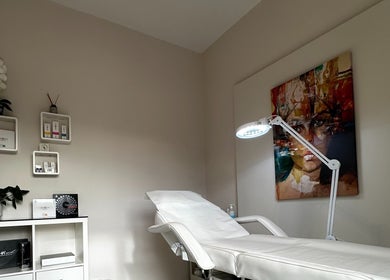 Αναπαυτικό κρεβάτι θεραπείας στο MEDITHEA Beauty & Health Experts, Αθήνα, GR, με διακόσμηση έργου τέχνης.