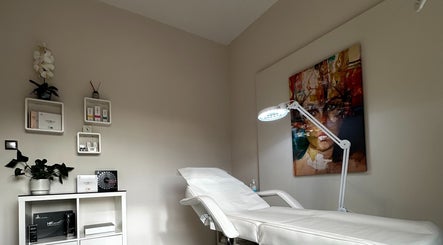 Αναπαυτικό κρεβάτι θεραπείας στο MEDITHEA Beauty & Health Experts, Αθήνα, GR, με διακόσμηση έργου τέχνης.