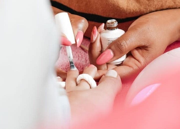 Nail artist applying pink polish at Kaybee Nails (Blessing), Cape Town, Western Cape, ZA.