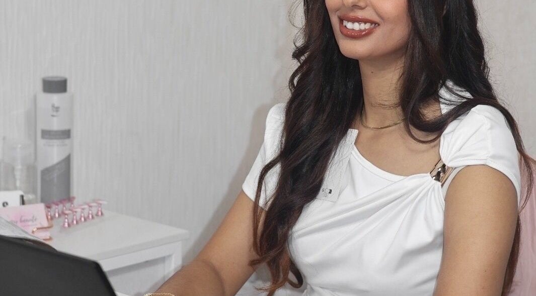 Professionnelle souriante à Oumay Beauty, Auxerre, Bourgogne-Franche-Comté, FR, offrant des services bien-être.