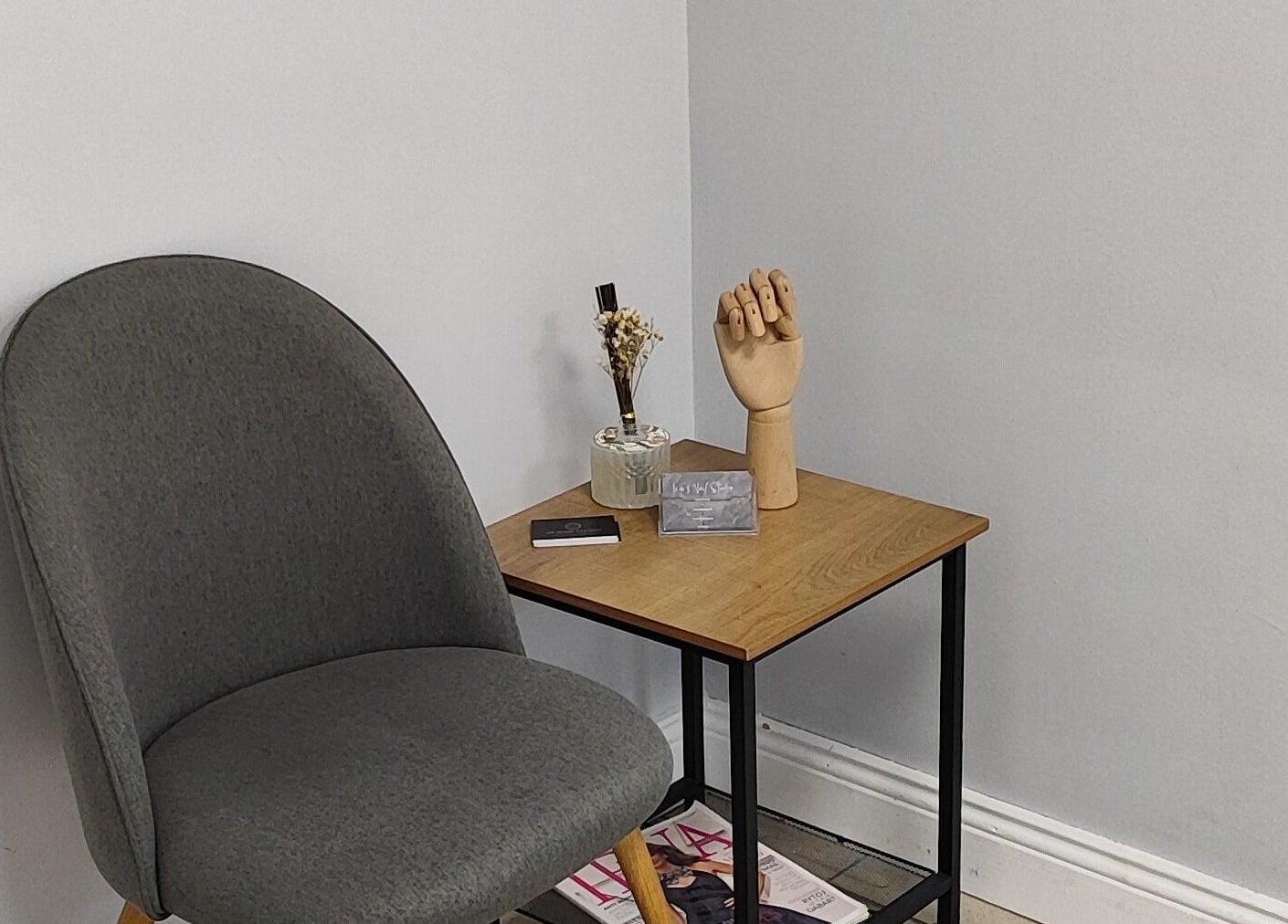 Cozy corner at Ieva's Nail Studio in Claregalway, IE featuring a gray chair and wooden decor.
