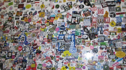 Vibrant sticker wall at Soul Frizerski Studio, Nova Gorica, capturing diverse artistic expressions.