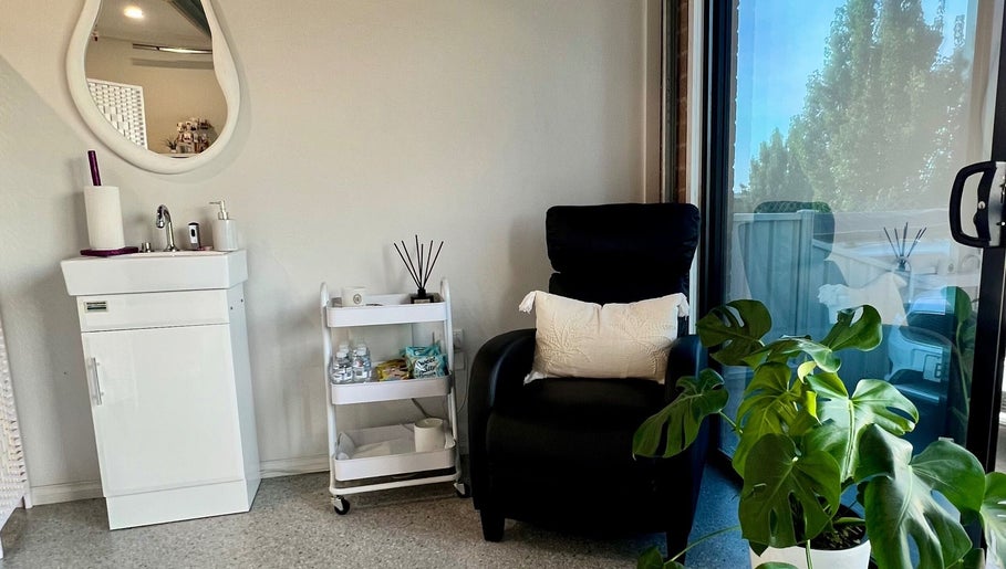 Relaxing corner at Bare Faced Beauty, Strath Creek, Victoria, AU with a chair, plant, and sink.