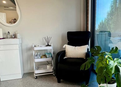 Relaxing corner at Bare Faced Beauty, Strath Creek, Victoria, AU with a chair, plant, and sink.