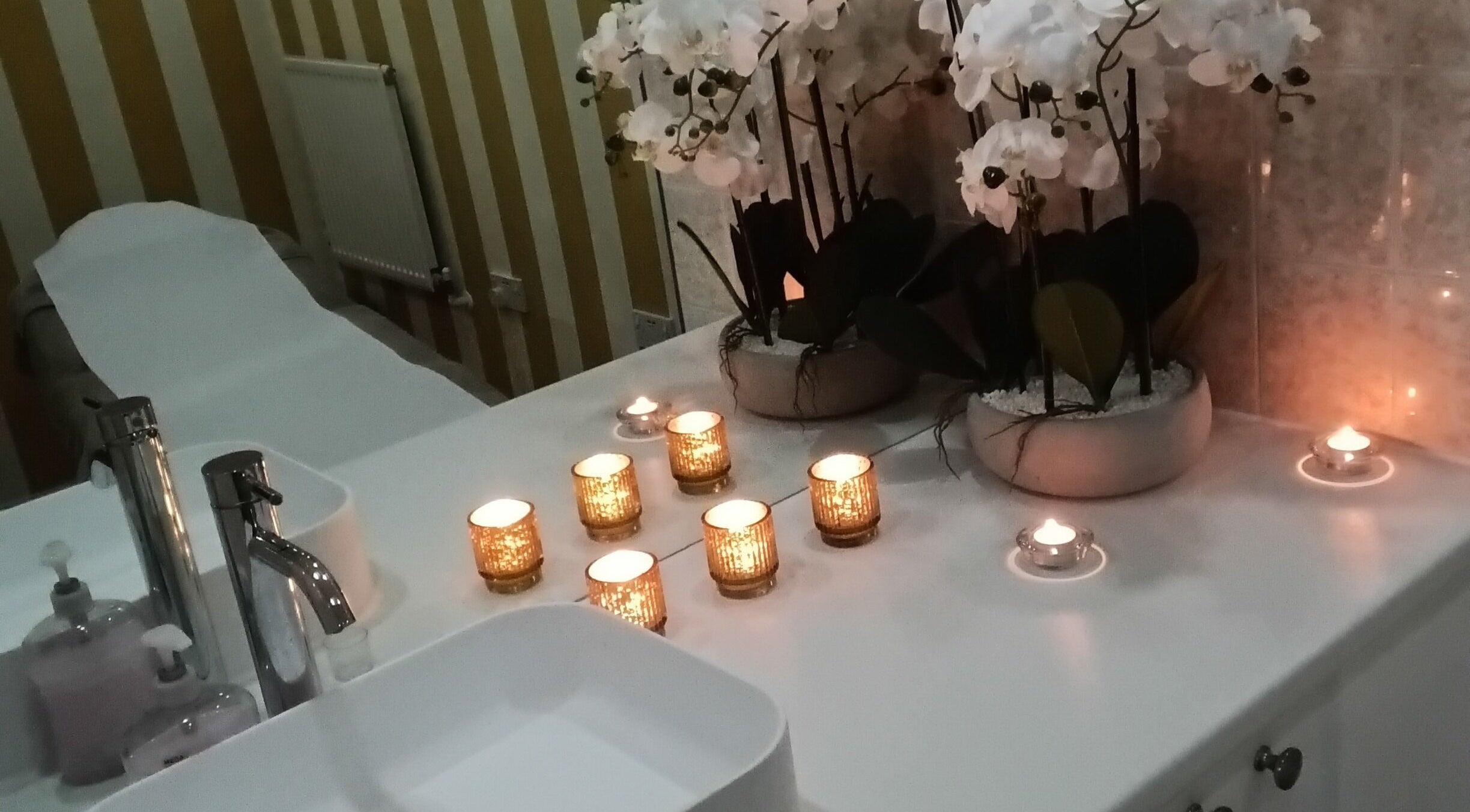 Relaxing spa setup at Allurez's Hair & Beauty in Dunkeld, Scotland, GB with candles and orchids.