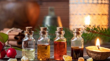 Bottiglie di oli essenziali a Armonia Di Un Massaggio, Bastia Umbra, Umbria, IT circondate da candele e decorazioni naturali.