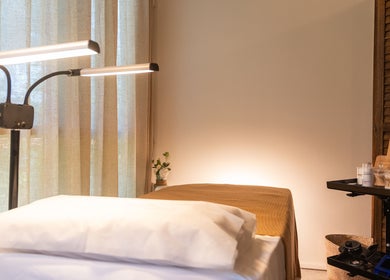 Serene treatment room at Brownee Studio x TNC Gallery, Singapore, SG, featuring cozy bed and warm lighting.