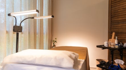Serene treatment room at Brownee Studio x TNC Gallery, Singapore, SG, featuring cozy bed and warm lighting.