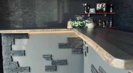 Интерьер VYBE House Barbershop в Риге с современным баром и декором.