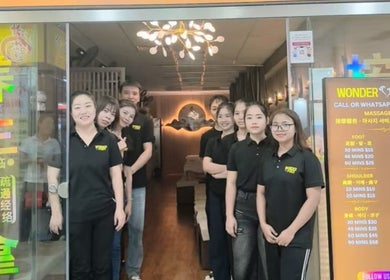 Friendly staff at Wonder Foot Spa entrance in Singapore, SG, ready to provide exceptional service.