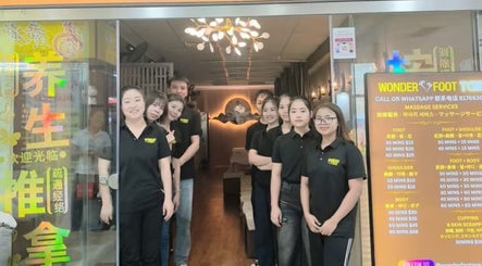 Friendly staff at Wonder Foot Spa entrance in Singapore, SG, ready to provide exceptional service.