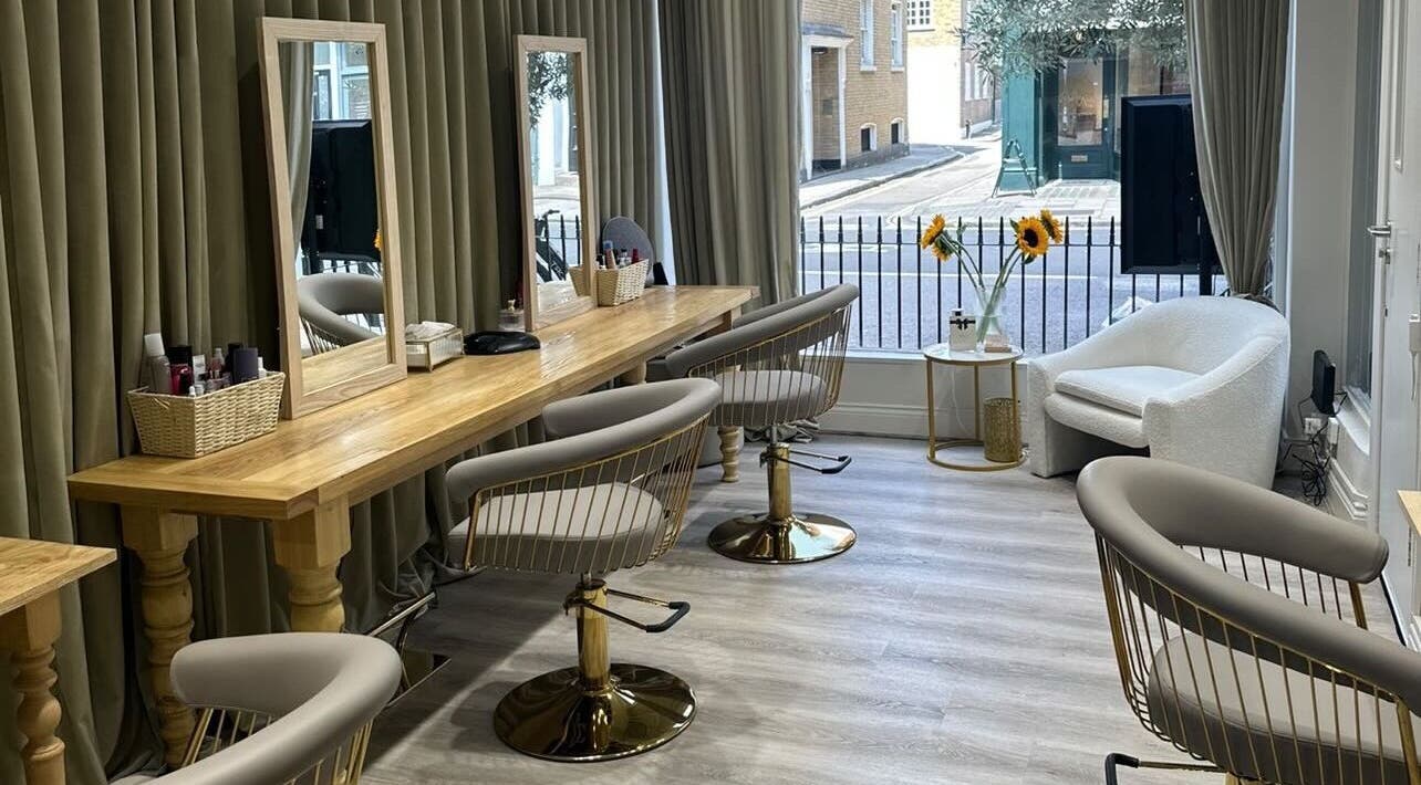 Modern salon interior at Irina G. Hair, London, England, GB featuring stylish chairs and wooden tables.