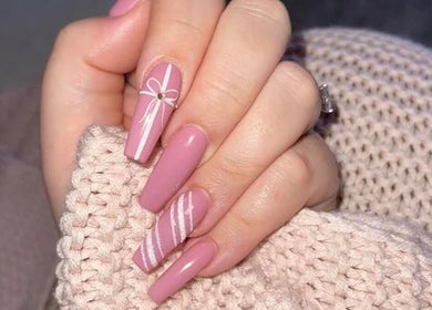 Móng tay nghệ thuật với họa tiết nơ hồng tại New York Nails, Nordenham, Niedersachsen, DE.