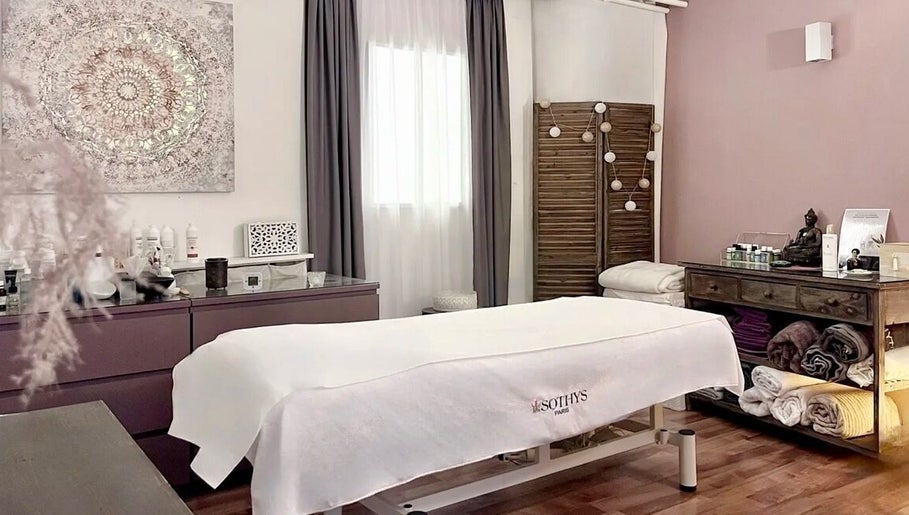 Salle de soins relaxante à Espace des Sens - Marie Meylan, Lausanne, Vaud, CH, avec table de massage et décor apaisant.