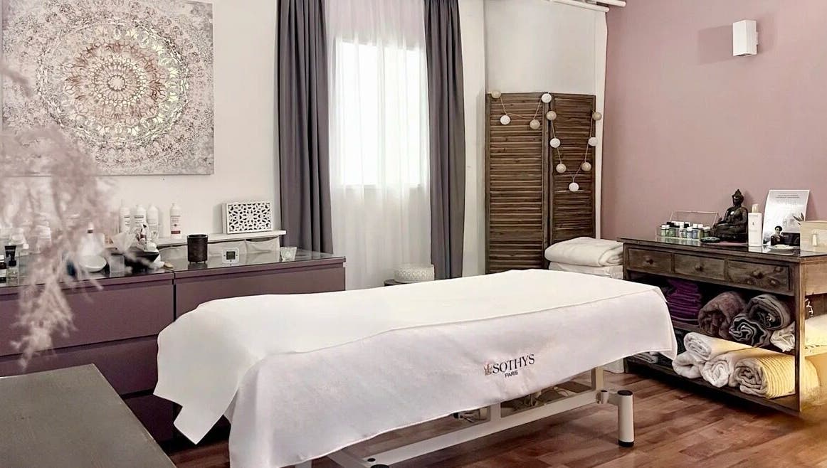 Salle de soins relaxante à Espace des Sens - Marie Meylan, Lausanne, Vaud, CH, avec table de massage et décor apaisant.