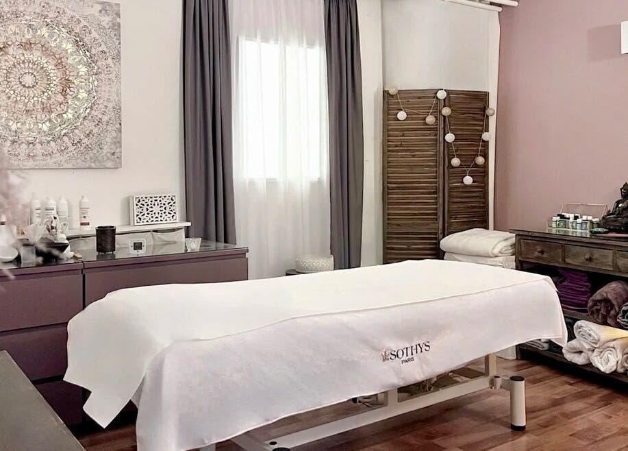 Salle de soins relaxante à Espace des Sens - Marie Meylan, Lausanne, Vaud, CH, avec table de massage et décor apaisant.