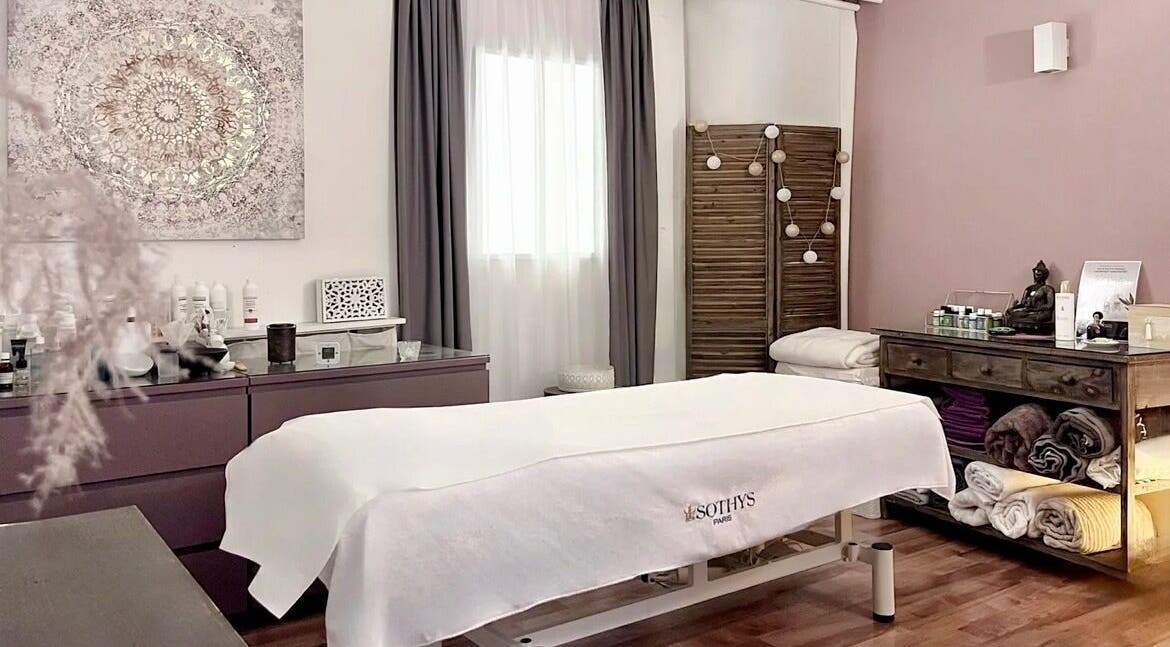 Salle de soins relaxante à Espace des Sens - Marie Meylan, Lausanne, Vaud, CH, avec table de massage et décor apaisant.