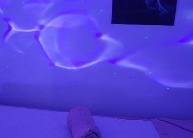 Relaxing massage room with calming purple lighting at Anchal Massage & Beauty Salon / Ladies Only, London, England, GB.