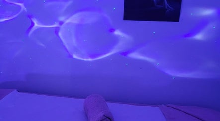 Relaxing massage room with calming purple lighting at Anchal Massage & Beauty Salon / Ladies Only, London, England, GB.