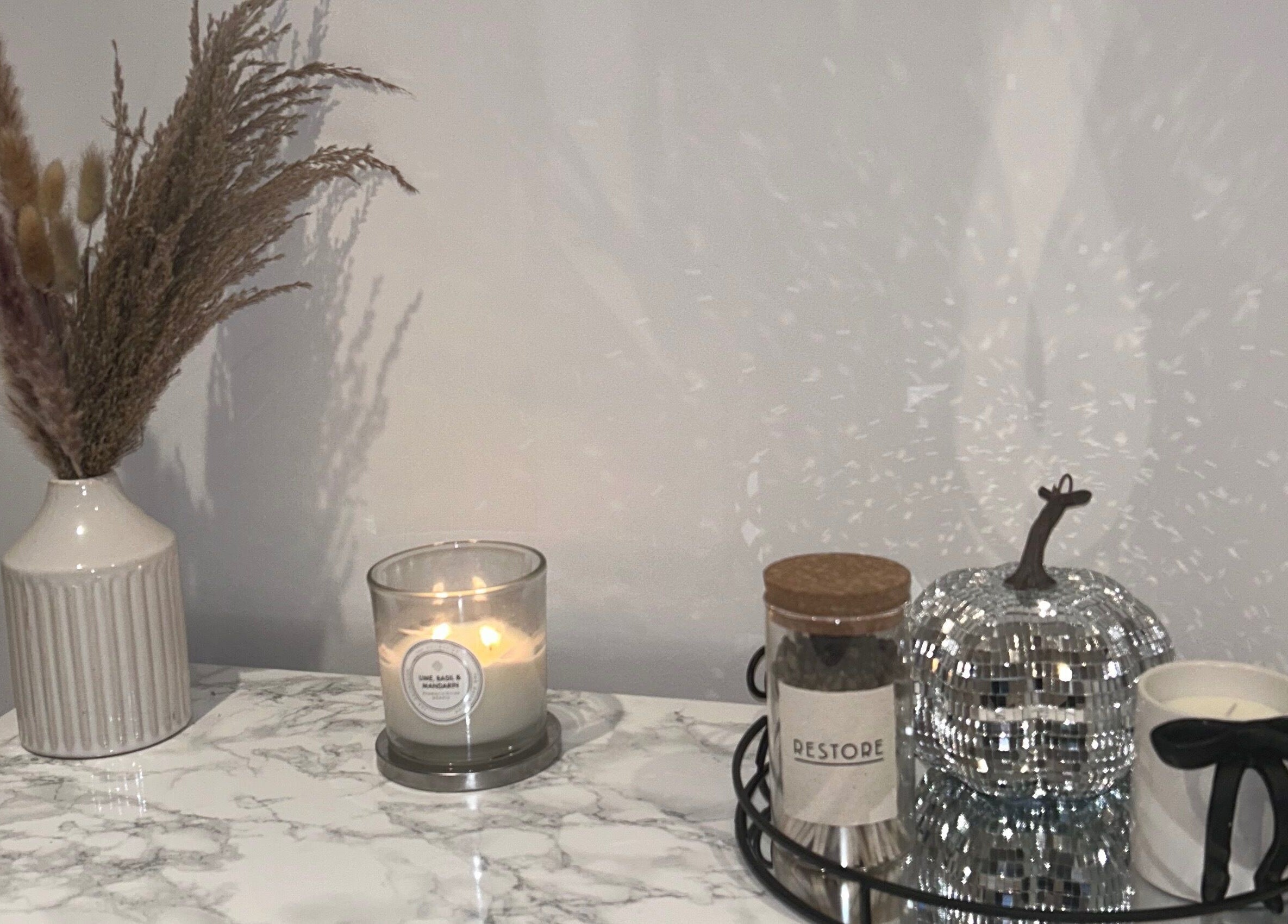 A serene setup at Studio by Mimi in Bedford, England, GB with a vase, candle, and decor elements.