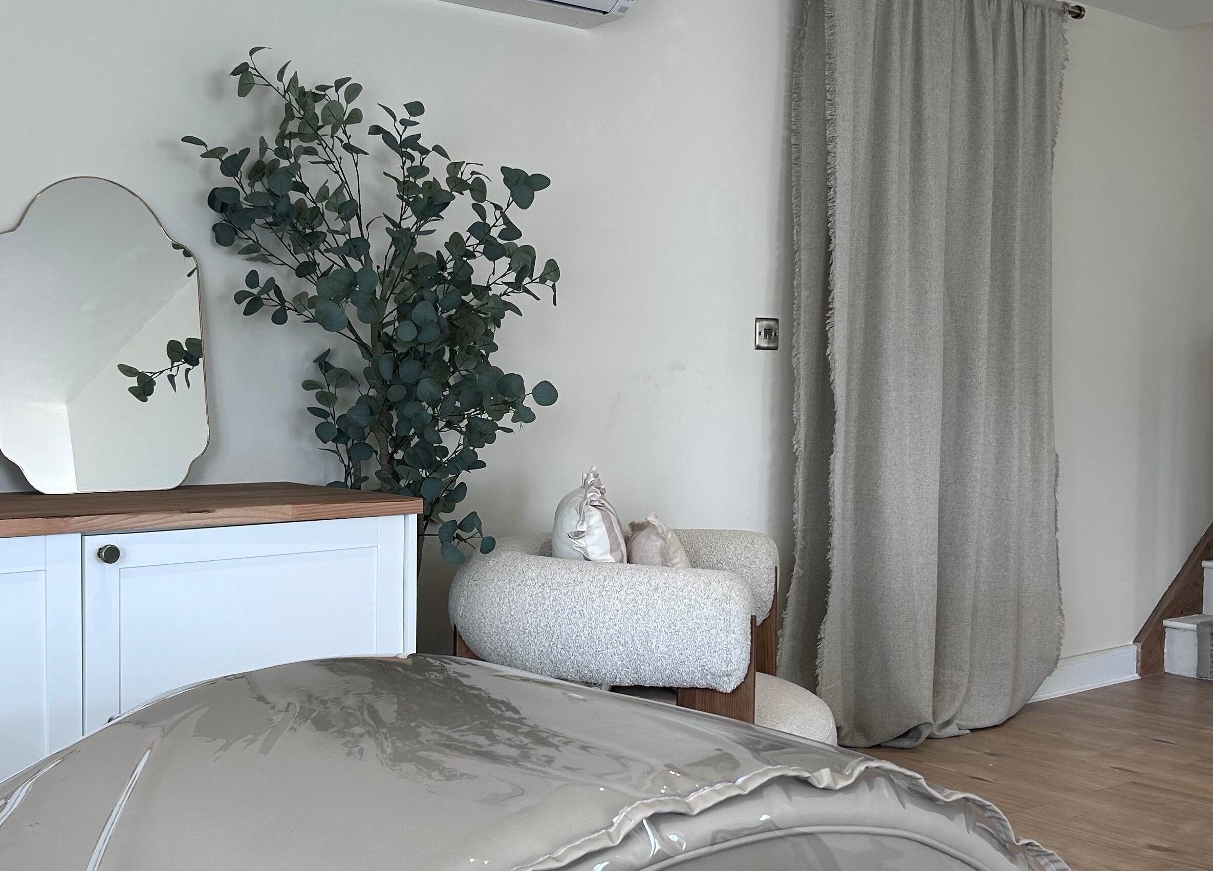 Cozy corner at Studio by Mimi - Only Studio in Bedford, England, GB with mirror, armchair, and plant decor.