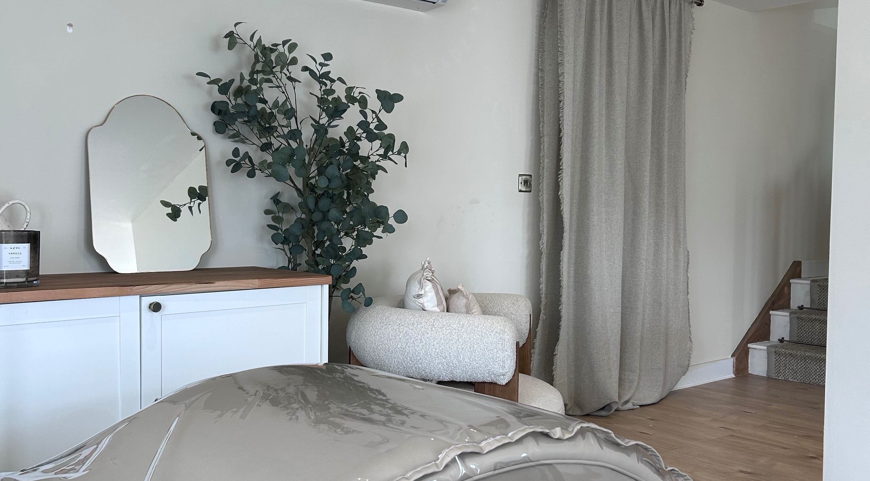 Cozy corner at Studio by Mimi - Only Studio in Bedford, England, GB with mirror, armchair, and plant decor.