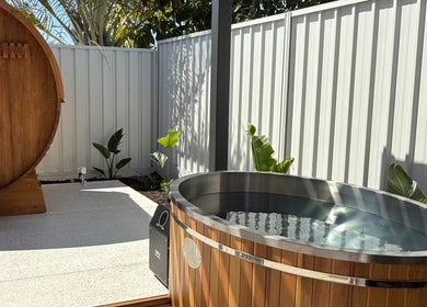 Outdoor barrel sauna and hot tub at Rise and Fall Wellness in Kallaroo, Western Australia, AU.