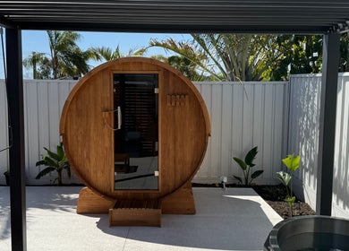 Wooden sauna at Rise and Fall Wellness, Kallaroo, Western Australia, AU, surrounded by greenery.