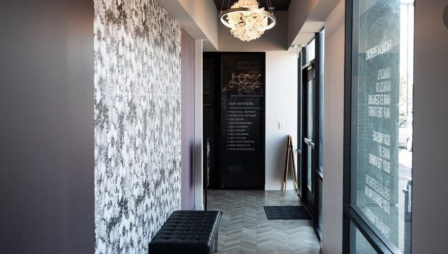 Elegant entryway of Marmac Studio, Chula Vista, California, US, featuring floral walls and a chandelier.