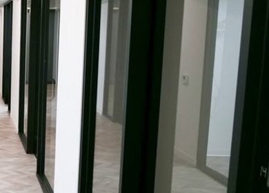 Modern hallway at Marmac Studio in Chula Vista, California, US, featuring sleek glass doors and a bright atmosphere.