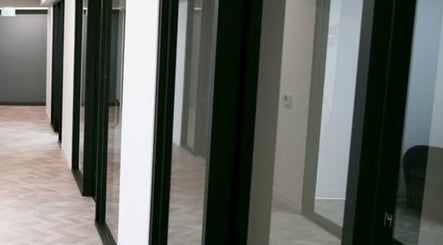Modern hallway at Marmac Studio in Chula Vista, California, US, featuring sleek glass doors and a bright atmosphere.
