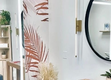 Chic interior of Marmac Studio in Chula Vista, California, showcasing a modern round mirror and plant decor.