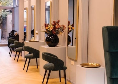 Moderne salon bij Ginzz in Den Haag, Zuid-Holland, NL met elegante stoelen en decoratieve planten.