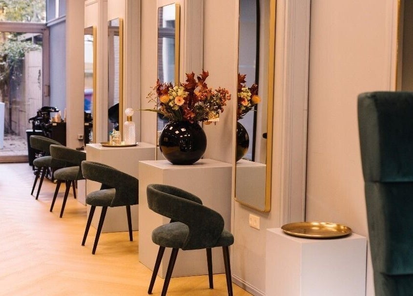 Moderne salon bij Ginzz in Den Haag, Zuid-Holland, NL met elegante stoelen en decoratieve planten.